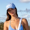 woman wearing a bikini top and the blue ron jon women's daisy cap