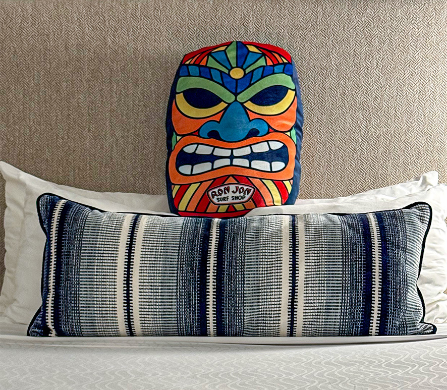 tiki face pillow on a bed