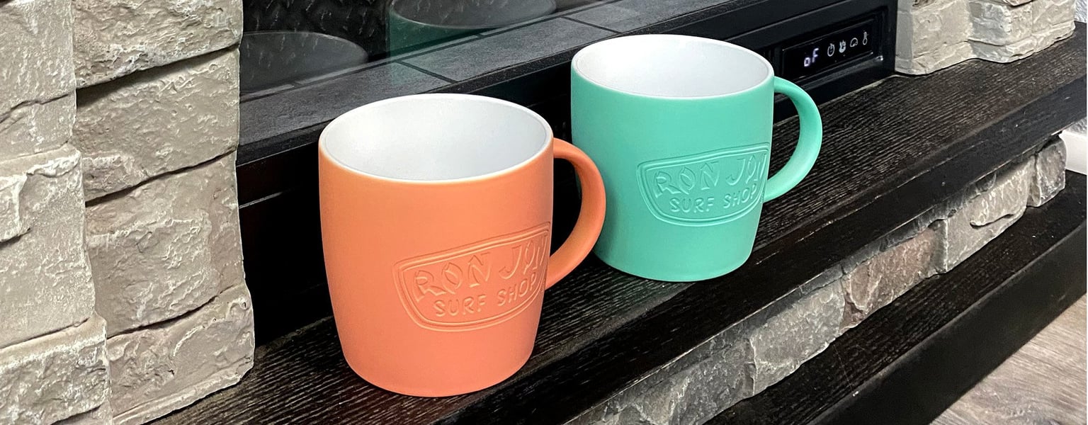 coral and turquoise color coffee mugs sitting on a fireplace hearth