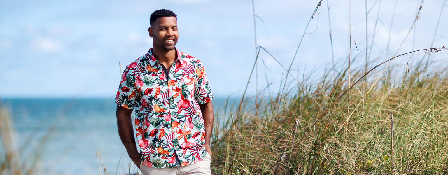 gentleman standing on the beach in a tropical themed button-up short-sleeve shirt