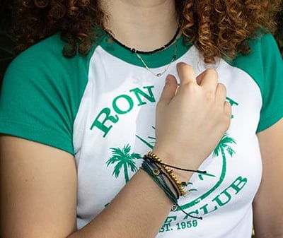 girl wearing a variety of beach-inspired bracelets and necklaces