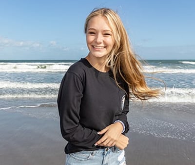 woman at the beach wearing a long-sleeve black tee shirt